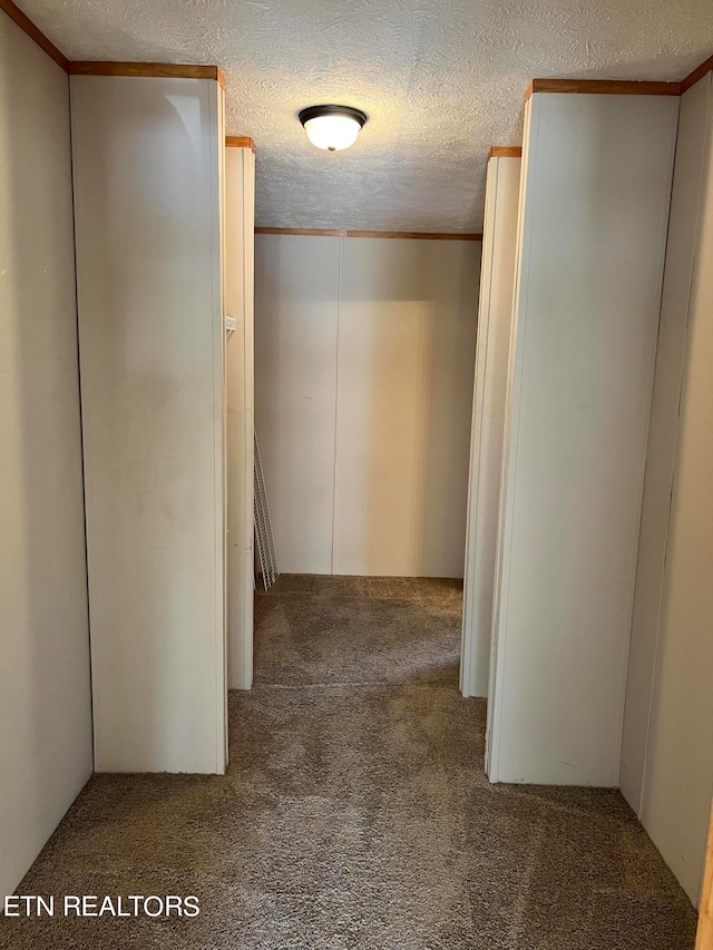 hallway with a textured ceiling and carpet flooring