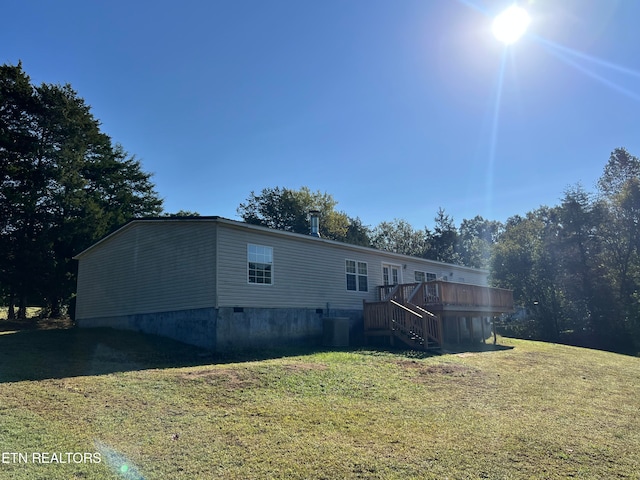 view of front facade with a front lawn, a deck, and central AC unit