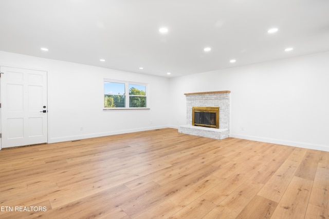 unfurnished living room featuring a fireplace and light wood-type flooring