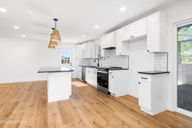 kitchen with appliances with stainless steel finishes, white cabinets, and light hardwood / wood-style floors