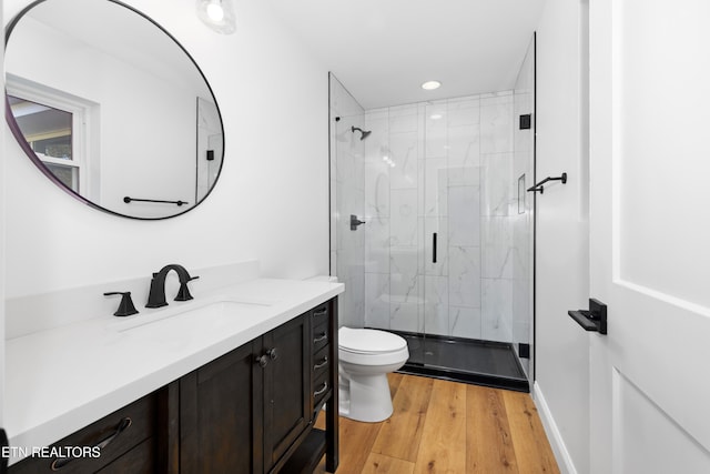 bathroom featuring vanity, hardwood / wood-style flooring, toilet, and an enclosed shower