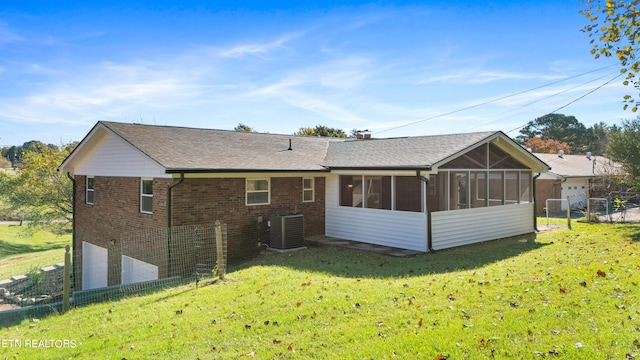 rear view of house featuring cooling unit, a lawn, and a sunroom