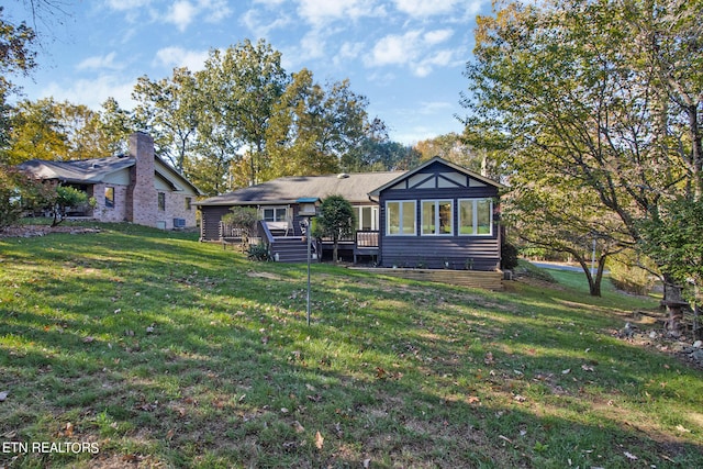 back of house featuring a yard and a wooden deck