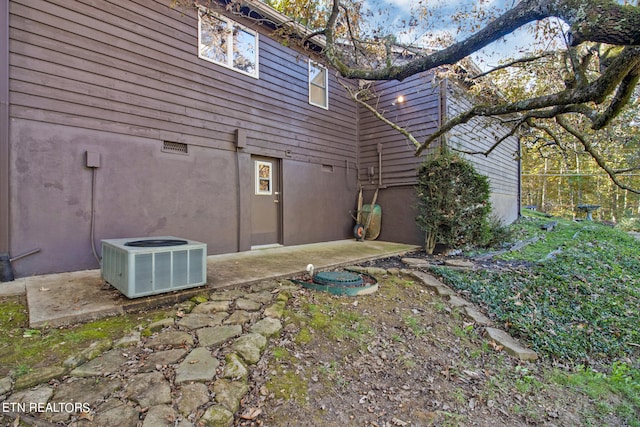 view of side of property featuring a patio and cooling unit