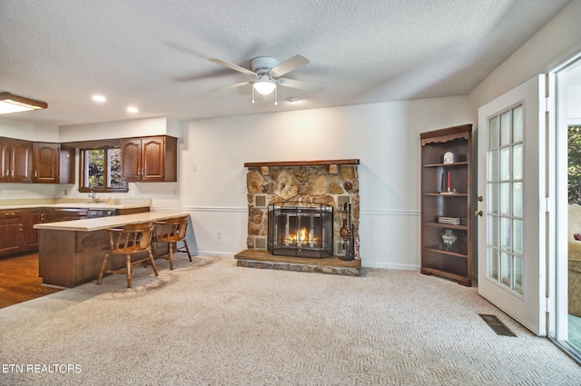 living room with carpet floors, a fireplace, and ceiling fan