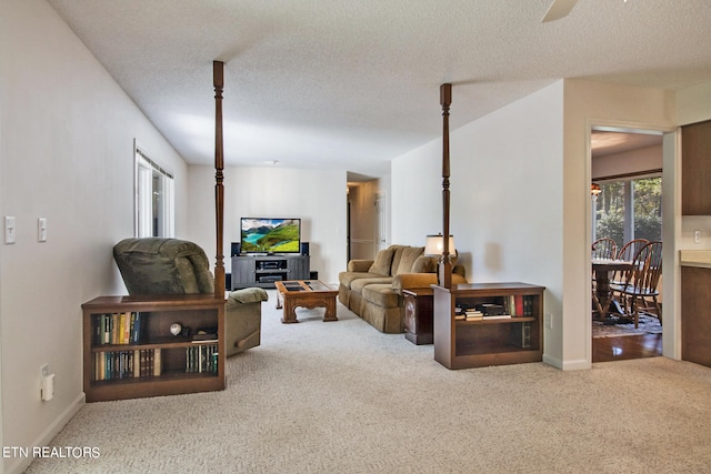 carpeted living room with a textured ceiling and ceiling fan