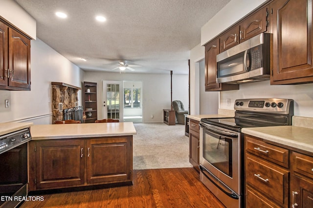 kitchen with dark wood-type flooring, stainless steel appliances, a textured ceiling, and ceiling fan