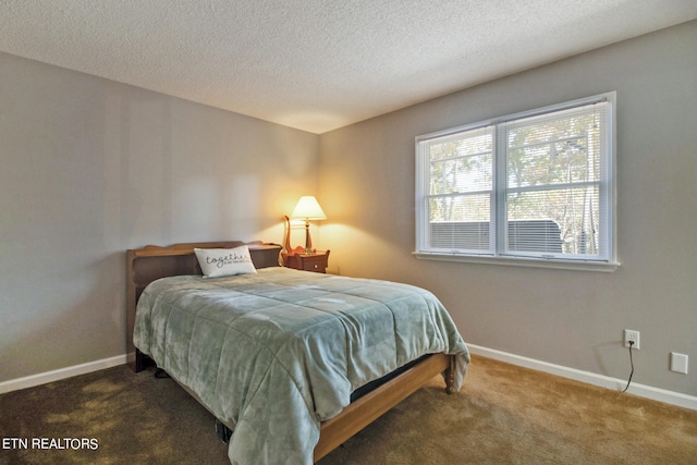 bedroom featuring a textured ceiling and dark carpet