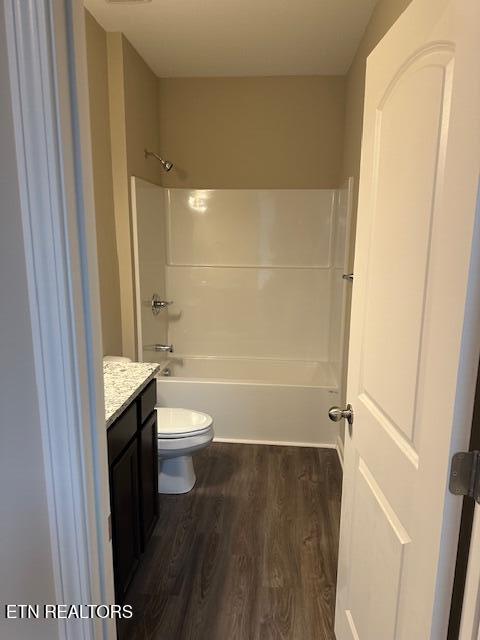 full bathroom with  shower combination, vanity, toilet, and wood finished floors