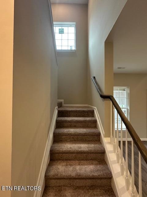 stairs with a healthy amount of sunlight and baseboards