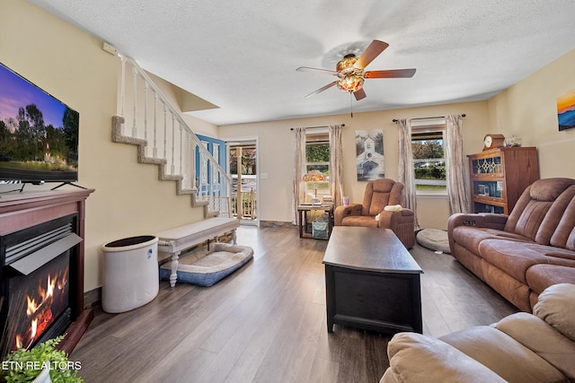 1440 Hicks Rd, Jefferson City, TN 37760 - living room featuring ceiling fan, wood finished floors, a warm lit fireplace, a textured ceiling, and stairway