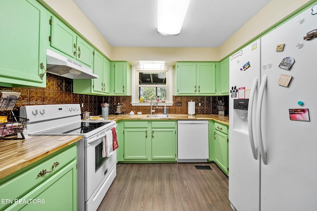 kitchen with under cabinet range hood, white appliances, a sink, light countertops, and green cabinetry