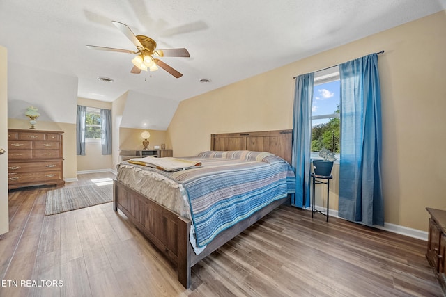 bedroom featuring vaulted ceiling, wood finished floors, a ceiling fan, and baseboards