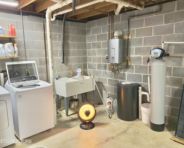 utilities featuring a sink, tankless water heater, and washer and dryer