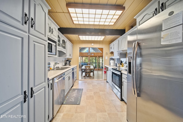 kitchen featuring gray cabinets, sink, appliances with stainless steel finishes, and light tile patterned floors