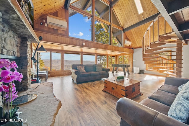 living room featuring wood-type flooring, beamed ceiling, a mountain view, high vaulted ceiling, and a wall mounted AC