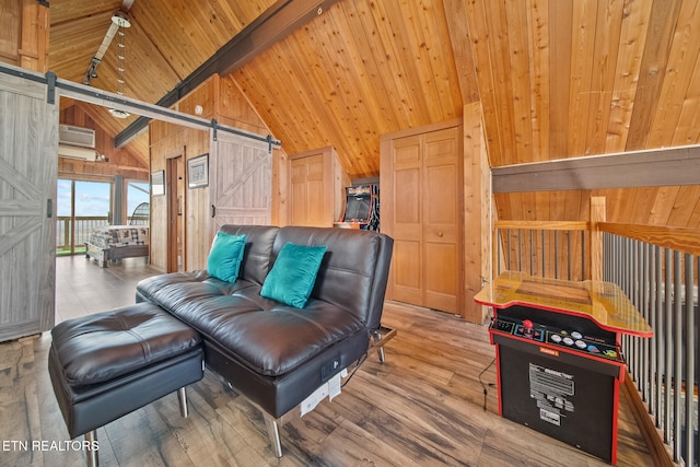 living room featuring a barn door, hardwood / wood-style floors, wooden walls, beam ceiling, and high vaulted ceiling