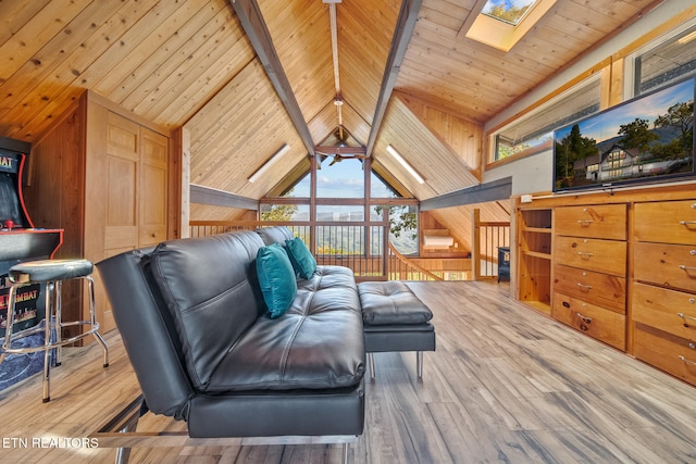 living room featuring beam ceiling, wooden walls, hardwood / wood-style floors, high vaulted ceiling, and a skylight