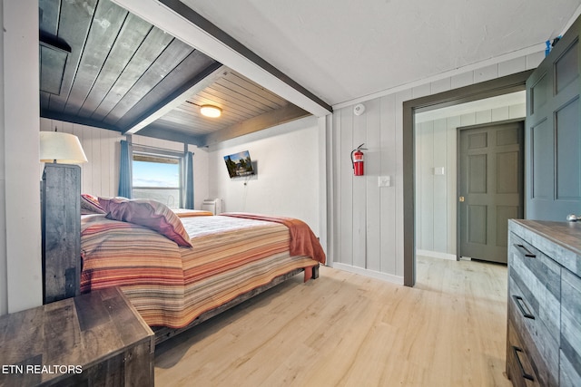 bedroom featuring light hardwood / wood-style floors, wood walls, beam ceiling, and wooden ceiling