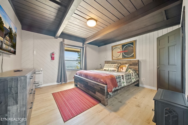 bedroom with light hardwood / wood-style floors, wood walls, beamed ceiling, and wooden ceiling