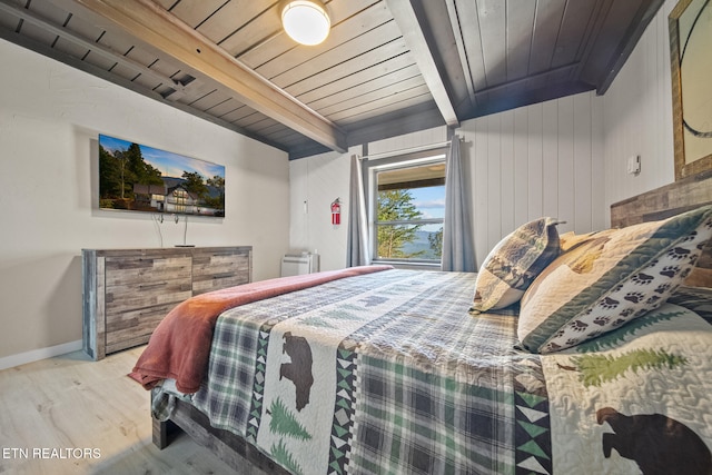 bedroom with beamed ceiling, light hardwood / wood-style flooring, and wood ceiling