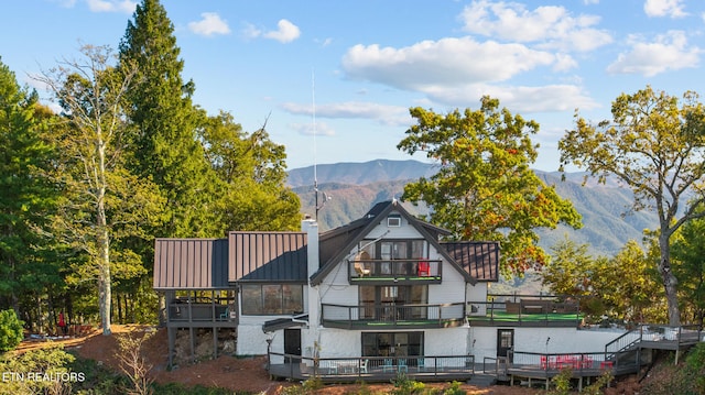 back of house featuring a balcony and a deck with mountain view