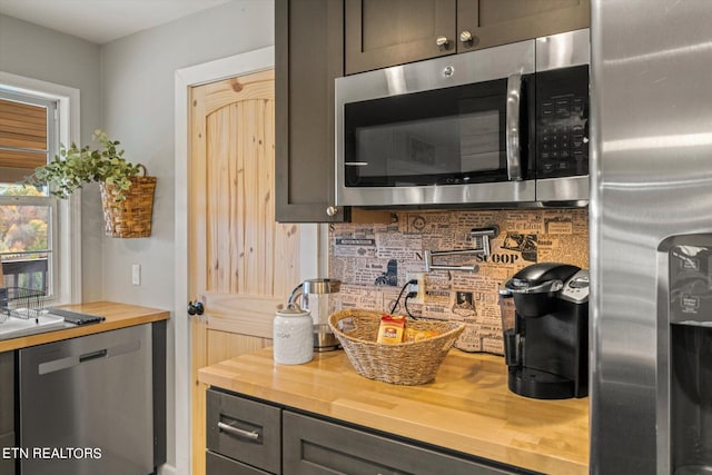 kitchen with tasteful backsplash, dark brown cabinetry, stainless steel appliances, and wood counters