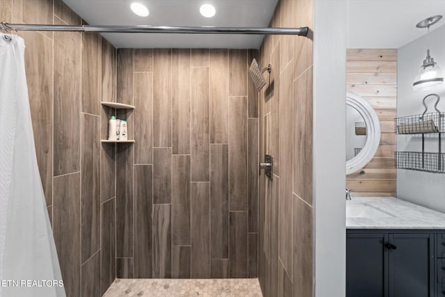 bathroom with vanity, wooden walls, and a shower with shower curtain