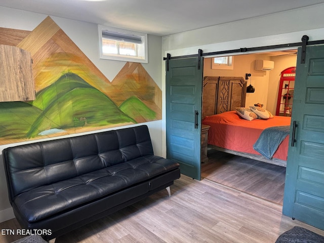 bedroom with an AC wall unit and wood-type flooring