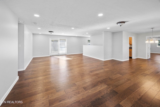 unfurnished room with dark wood-type flooring and a textured ceiling