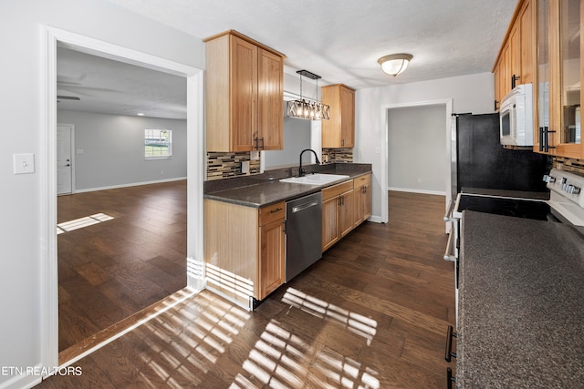 kitchen featuring stainless steel appliances, dark wood-style flooring, a sink, and backsplash