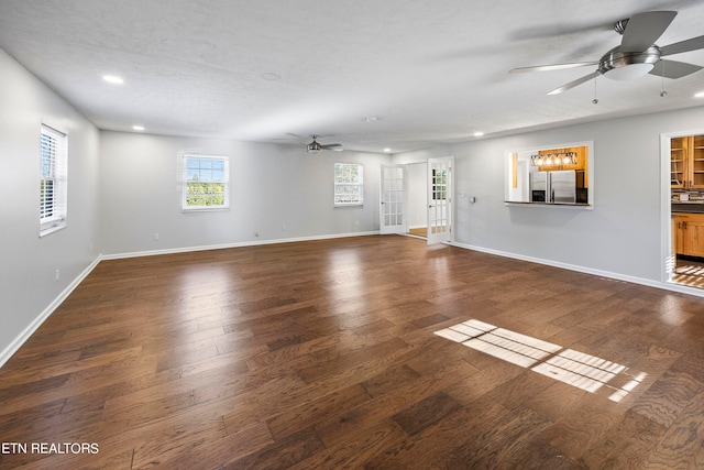 unfurnished living room featuring a textured ceiling, dark hardwood / wood-style floors, and ceiling fan