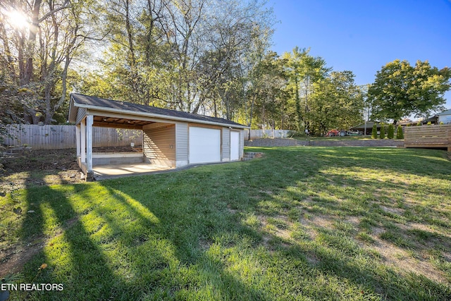 view of yard featuring an outbuilding, fence, and a detached garage