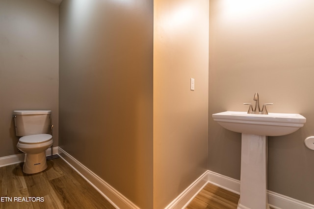 bathroom featuring wood-type flooring and toilet