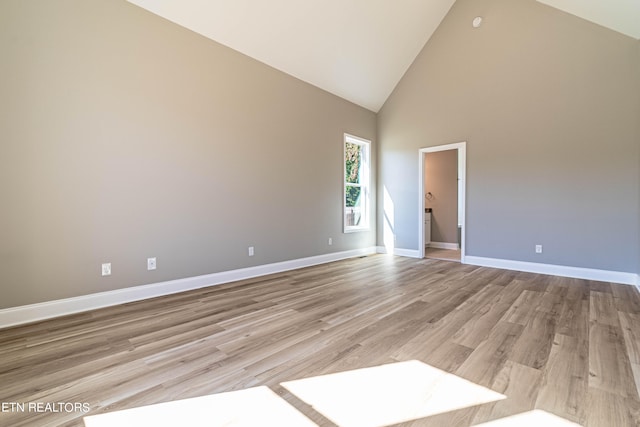 empty room featuring light hardwood / wood-style floors and high vaulted ceiling