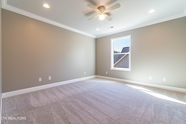 empty room with baseboards, visible vents, light colored carpet, a ceiling fan, and ornamental molding