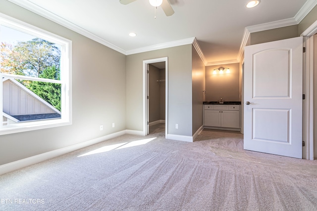 unfurnished bedroom with a closet, a walk in closet, ornamental molding, light colored carpet, and ceiling fan