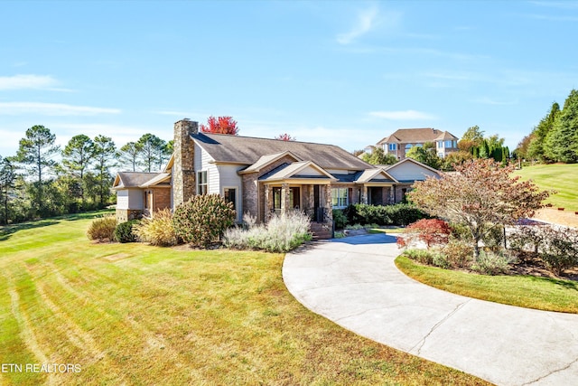3909 Logans Landing Cir, Louisville, TN 37777 - view of front facade with a chimney, brick siding, curved driveway, and a front yard