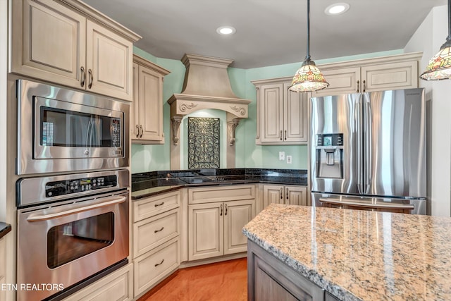 3909 Logans Landing Cir, Louisville, TN 37777 - kitchen featuring pendant lighting, appliances with stainless steel finishes, light wood-style floors, light stone countertops, and cream cabinets