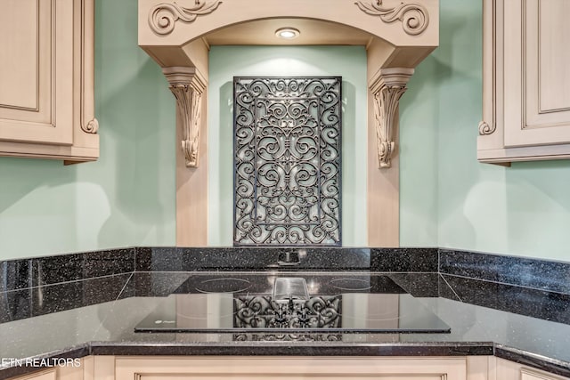 3909 Logans Landing Cir, Louisville, TN 37777 - kitchen with cream cabinets, black electric cooktop, dark stone countertops, and decorative columns