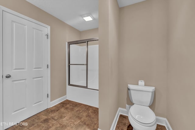 bathroom featuring toilet and enclosed tub / shower combo