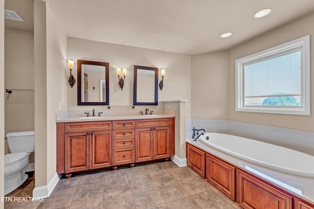 bathroom with vanity, toilet, and a washtub