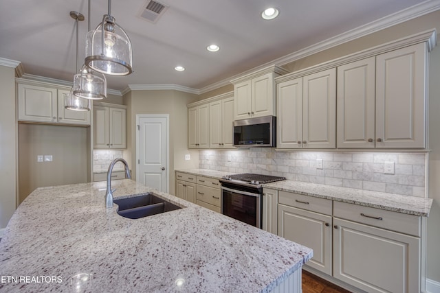 kitchen featuring light stone counters, appliances with stainless steel finishes, sink, and hanging light fixtures