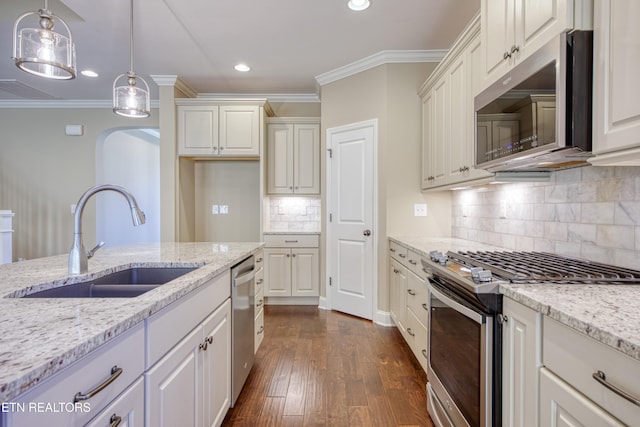 kitchen with dark hardwood / wood-style flooring, appliances with stainless steel finishes, white cabinetry, sink, and decorative light fixtures