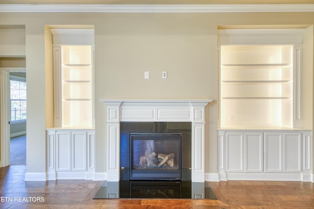 room details with ornamental molding, built in shelves, and hardwood / wood-style floors