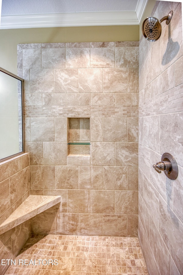 bathroom featuring ornamental molding and tiled shower