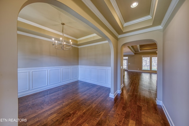 unfurnished dining area featuring dark wood-type flooring, crown molding, and a raised ceiling