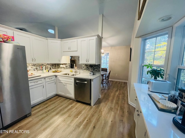 kitchen with backsplash, light hardwood / wood-style floors, sink, stainless steel appliances, and white cabinets