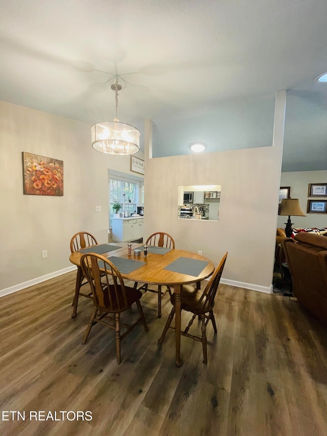 dining space with dark wood-type flooring and a chandelier