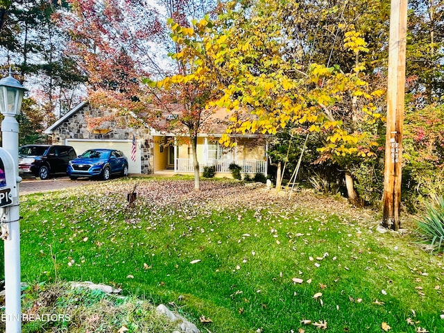 obstructed view of property with a garage, a front yard, and covered porch